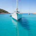 Mouiller son bateau : voilier à l'ancre dans une baie abritée aux eaux turquoise